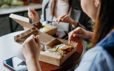 Image of two asian businesswomen eating take away food together during lunch break